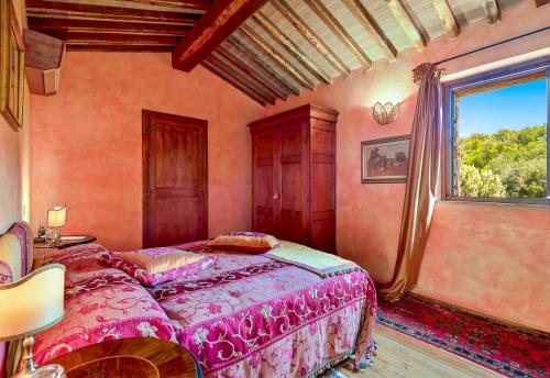 a bedroom with a pink bed and a window at Villa Experience - Relais Il Termine Elba in Rio Marina