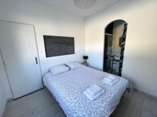 a bedroom with a bed with two towels on it at Siam Mahanakhon Appart & Spa in Rieux-de-Pelleport