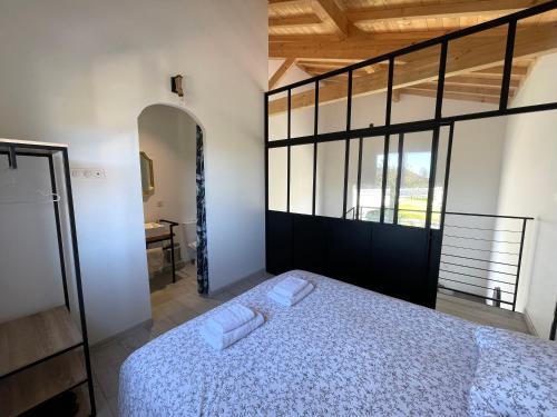 a bedroom with a bed with two towels on it at Siam Mahanakhon Appart & Spa in Rieux-de-Pelleport