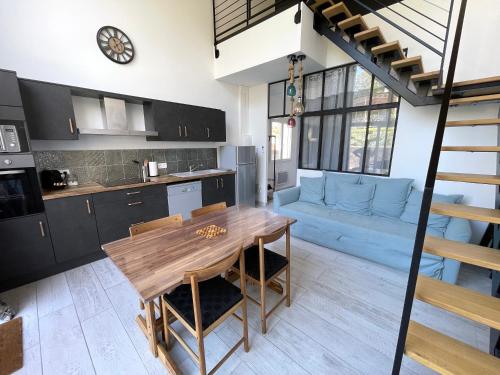 a kitchen and living room with a wooden table at Siam Mahanakhon Appart & Spa in Rieux-de-Pelleport