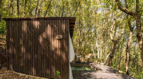 a wooden boardwalk leading to a cabin in the woods at Villa Experience - Relais Il Termine Elba in Rio Marina