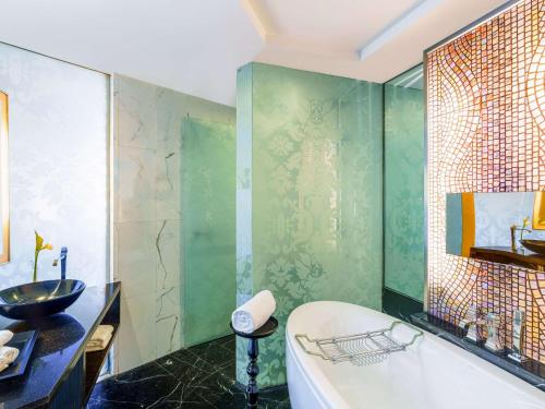 a bathroom with a bath tub and a sink at Sofitel Mumbai BKC in Mumbai