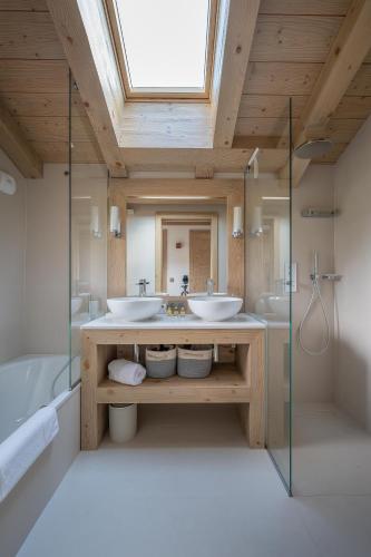 une salle de bain avec deux lavabos et un grand miroir dans l'établissement Chalet Valerie, aux Gets