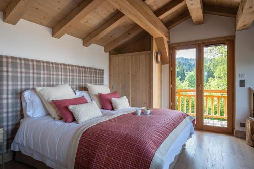 une chambre avec un grand lit avec des oreillers rouges et blancs dans l'établissement Chalet Valerie, aux Gets
