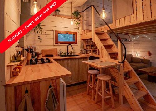 a kitchen with a spiral staircase in a tiny house at L'Abri des Rêves in Aydat