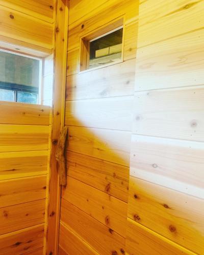 a wooden wall in a cabin with a window at えん吉野絶景広がる隠れ家1棟貸切ペットokサウナ室完備 in Yoshino