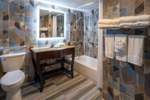 a bathroom with a toilet and a sink and a tub at Days Hotel by Wyndham North Bergen in North Bergen