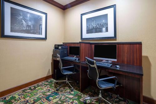 a room with a desk with a computer and two chairs at Days Hotel by Wyndham North Bergen in North Bergen