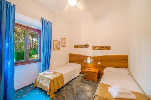 a room with two beds and a window at Tenuta Delle Ripalte in Capoliveri