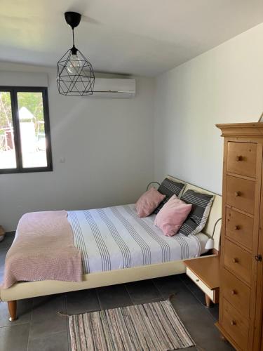 - une chambre avec un lit et 2 oreillers roses dans l'établissement Petite maison au cœur des Châteaux de la Loire, à Onzain