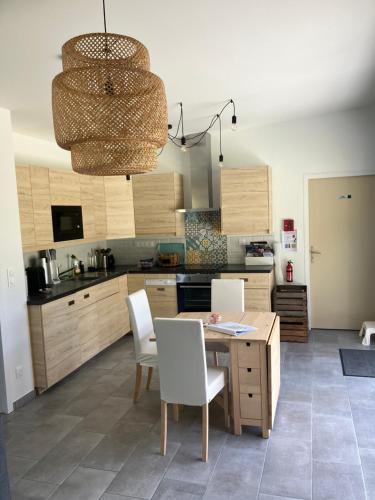 - une cuisine avec une table en bois et des chaises blanches dans l'établissement Petite maison au cœur des Châteaux de la Loire, à Onzain