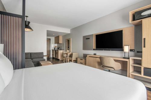 a hotel room with a bed and a living room at Hyatt Place Newark-Silicon Valley in Newark