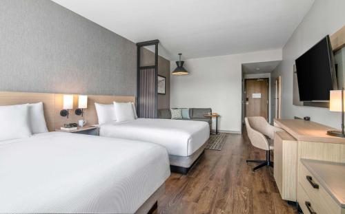 a hotel room with two beds and a flat screen tv at Hyatt Place Newark-Silicon Valley in Newark