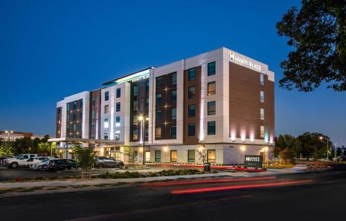 a building with cars parked in a parking lot at Hyatt Place Newark-Silicon Valley in Newark