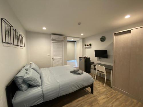 a bedroom with a bed and a desk in it at Aree House Poshtel in Pattaya South
