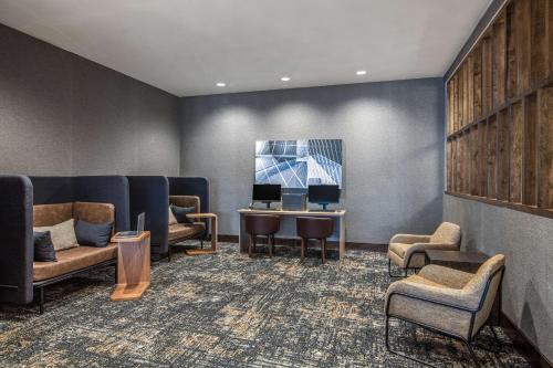 a waiting room with couches and a table and chairs at Hyatt Place Newark-Silicon Valley in Newark