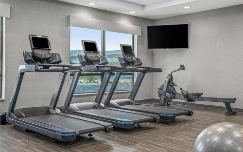 a gym with a treadmill and a flat screen tv at Hyatt Place Newark-Silicon Valley in Newark
