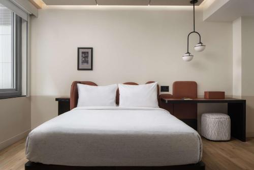 a bedroom with a large bed and a desk at Motto By Hilton New York City Times Square in New York