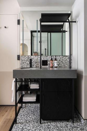 a bathroom with a black sink and a mirror at Motto By Hilton New York City Times Square in New York