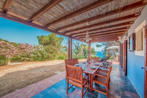 a dining table on a patio with a view of the ocean at Tenuta Delle Ripalte in Capoliveri