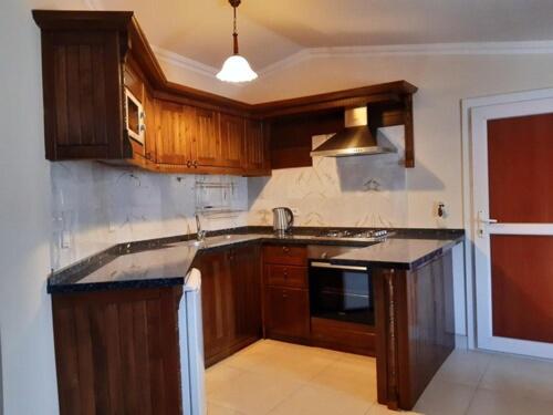 a kitchen with wooden cabinets and a black counter top at Central Park Otel - Adult Only in Dalyan