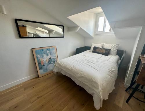 une chambre avec un lit et un miroir au mur dans l'établissement Beau studio au cœur de Nice, à Nice