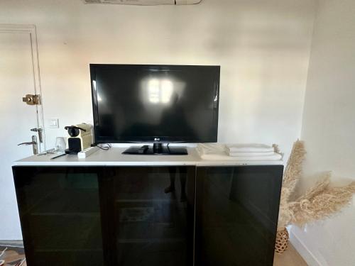 a desk with a large television on top of it at Beau studio au cœur de Nice in Nice
