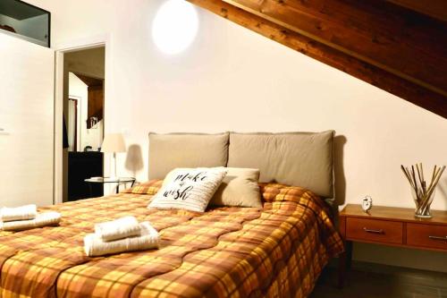 a bedroom with a bed with two towels on it at Attico nel cuore delle Langhe - Free Parking Wi-Fi e AC in Alba