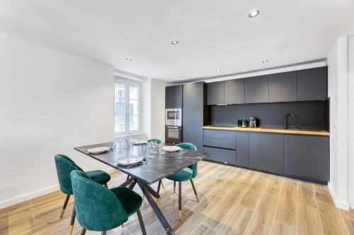 une cuisine et une salle à manger avec une table et des chaises dans l'établissement Appartement Hyper Centre Evian - Côté Théâtre, à Évian-les-Bains