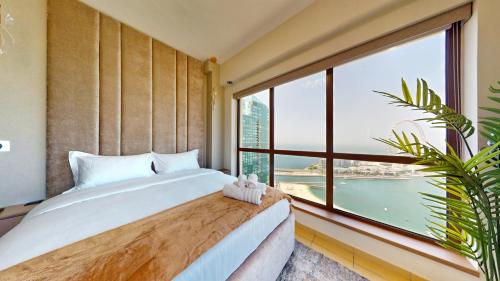 a bedroom with a bed and a large window at Amazing views Dubai eye & Palm in Dubai