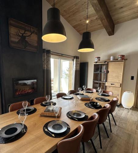 une salle à manger avec une grande table en bois avec des chaises dans l'établissement La Montagne 2 ALPES 12 pers standing skis au pied, à Les Deux Alpes