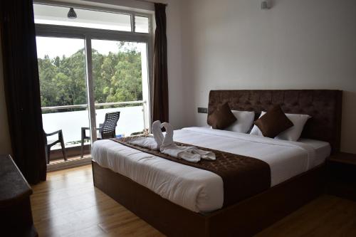 A bed or beds in a room at Hotel NT Grand Yercaud