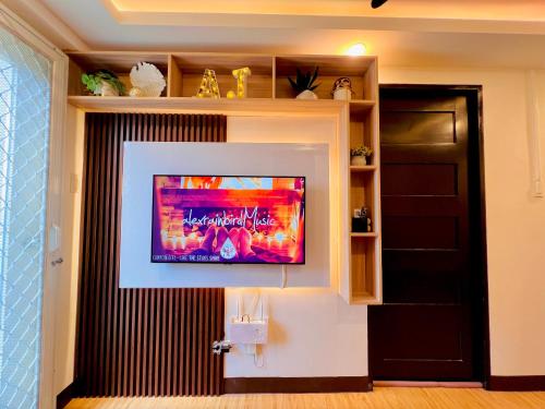 een woonkamer met een televisie aan de muur bij Athena’s Den in Davao City