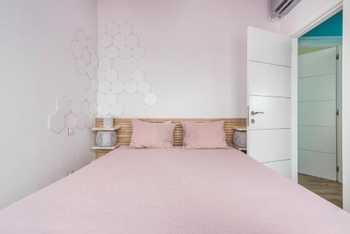 une chambre avec un grand lit avec des oreillers roses dans l'établissement La Casa Blanca a smart and sunny,3 bedrooms house, à San Bartolomé