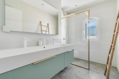 une salle de bain blanche avec un lavabo et un miroir dans l'établissement La Casa Blanca a smart and sunny,3 bedrooms house, à San Bartolomé