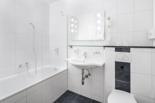 e bagno con lavandino, servizi igienici e vasca. di 4-Länder-Hotel Deutschmann a Bregenz