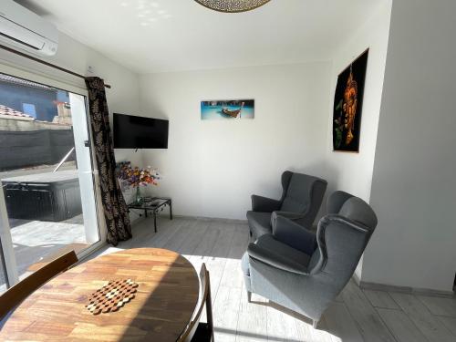 a living room with two chairs and a table at Siam Mahanakhon Appart & Spa in Rieux-de-Pelleport