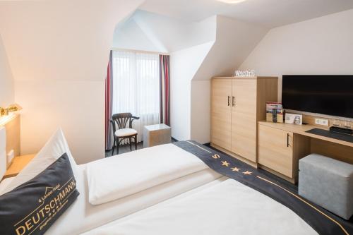 a hotel room with a bed and a flat screen tv at 4-Länder-Hotel Deutschmann in Bregenz