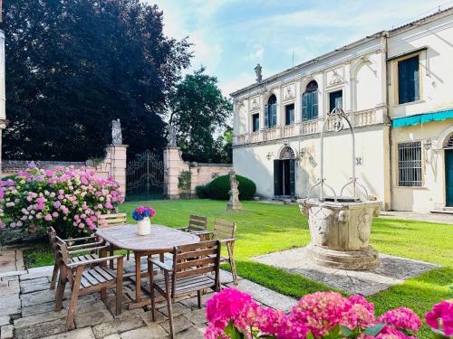 un giardino con tavolo, sedie e fontana di Veneto Villa in Padua a Villa Osti