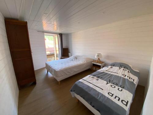 1 Schlafzimmer mit 2 Betten in einem Zimmer mit Fenster in der Unterkunft Cottage viva la vida in Auzon