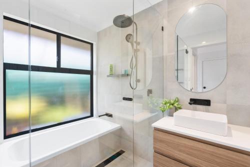 a bathroom with a sink and a mirror and a window at Busselton Family Holiday House - by the Bay in Geographe
