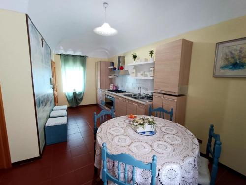 een keuken met een tafel en stoelen en een keuken met een wastafel bij La Finestra sul Corso in Bucchianico