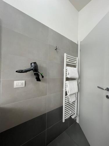 uma casa de banho com chuveiro, secador de cabelo e toalhas em Appartamento Noi Due em Riva del Garda