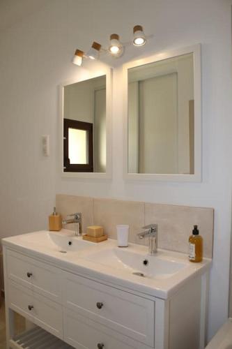 une salle de bain avec un lavabo blanc et un miroir dans l'établissement Mas en campagne, à Mallemort