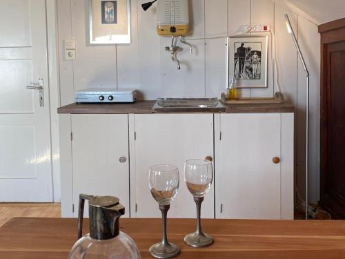 dos copas de vino sentadas en una mesa en una cocina en Dachgeschoss im Künstlerhaus en Samerberg