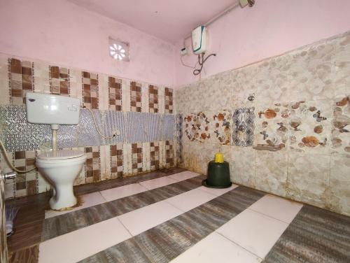 a bathroom with a toilet in a room at Whiterann village Homestay in Dhordo