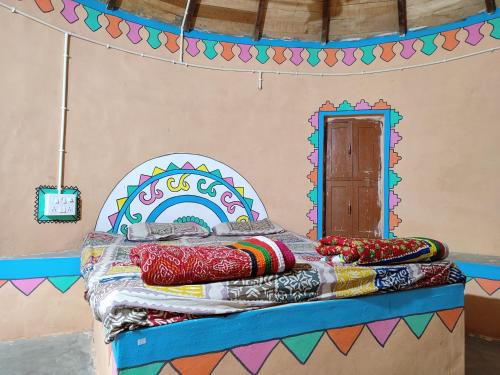 a bedroom with a bed with a colorful bedspread at Whiterann village Homestay in Dhordo