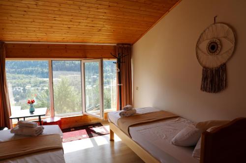 a bedroom with two beds and a large window at Nadia Guesthouse in Mestia