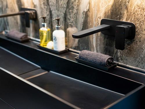 a bathroom counter with a sink with two bottles of soap at Luxury City Centre Oasis - Lux Spa Bath - Romantic in Edinburgh
