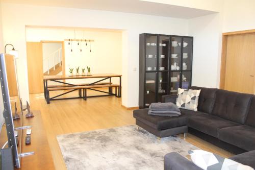 a living room with a black couch and a table at Casa dos Amigos - Arouca in Arouca